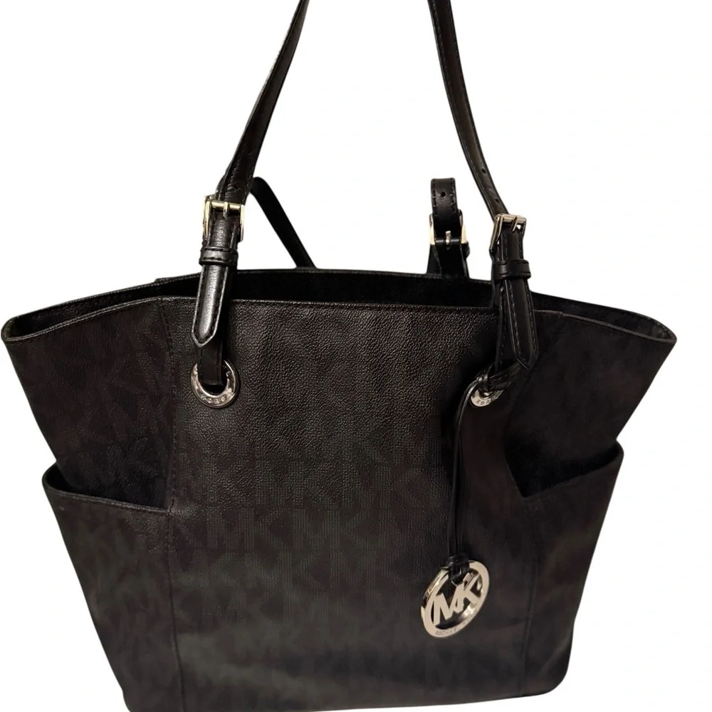 Michael Kors Elegant Black Handbag. Sides packets with a log in the front